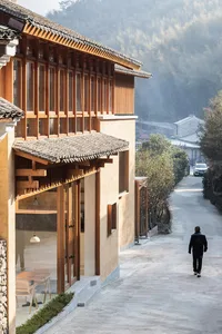 A traditional stone road with wooden structures and glass windows in a rural landscape.