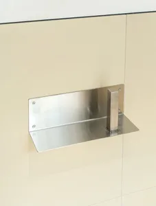 A modern metal locking device attached to a tiled wall.