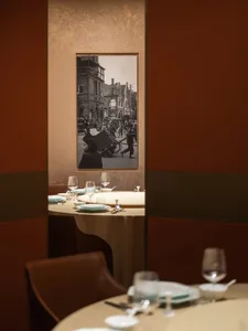 Restaurant interior with brown leather seating and a framed photograph of an urban scene.