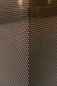 Close-up view of a perforated metal surface, highlighting its industrial aesthetic.
