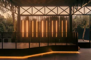 Modern lounge area featuring sleek metal elements, transparent glass, and linear lighting, creating a sophisticated and conte