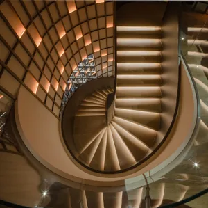 Modern penthouse featuring a floating staircase with wooden steps and a circular glass railing.