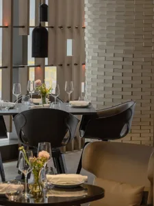 Modern restaurant interior with black chairs, white walls, and wooden accents