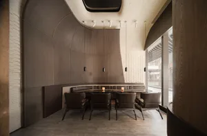 Modern restaurant interior featuring concrete walls and wooden furniture.