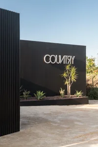 Black wall with modern 'COUNTRY' signage and concrete ground in an office entryway