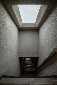 Concrete stairwell with natural light from a skylight.