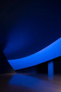 An abstract, futuristic interior design featuring bold blue lighting and geometric shapes.