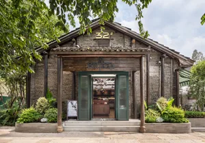 A rustic restaurant with a brick exterior and tile roof surrounded by lush greenery, featuring the number 32 and the name 'La