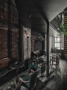 Industrial-style coffee shop interior with brick walls, concrete floor, and metal furniture.