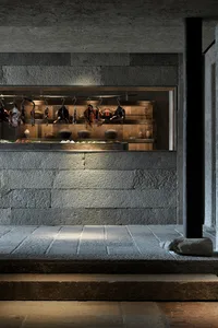 An industrial interior space with concrete walls and hanging items.