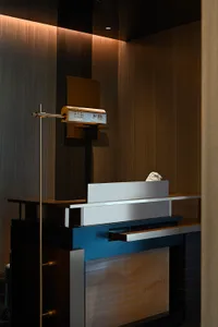 Modern minimalist lobby featuring metallic finishes, glass elements, and stone accents.