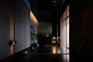 Modern, minimalist entry-way featuring concrete surfaces and a sleek, dark design.