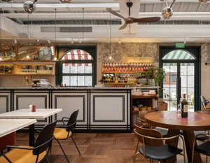 Modern industrial restaurant interior with tile flooring, bar counter, and chairs.