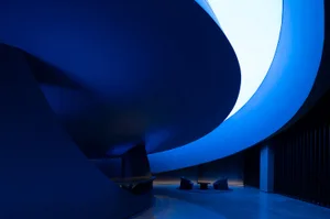 A modern lobby with blue curved walls and seating area