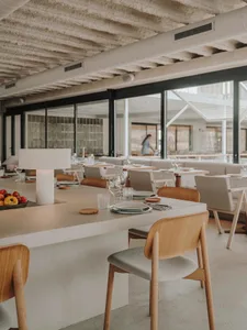 A modern restaurant with a concrete counter featuring minimalist décor and seating areas.