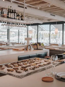 Oyster bar with granite flooring and a variety of raw oysters on ice.