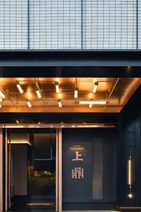 Modern entrance to a restaurant featuring metallic and glass materials.