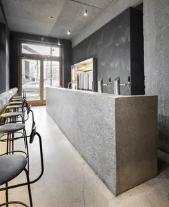 Industrial-style bar counter with concrete finish and stools