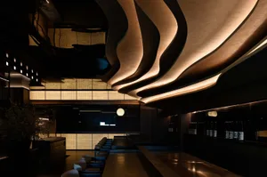 A stylish and contemporary restaurant bar with modern design elements, including glass and concrete materials.