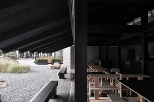 Wooden and concrete café interior with black structural elements.
