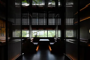 A modern restaurant interior featuring comfortable leather seating and glass paneling.