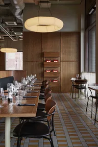 Modern restaurant with wooden tables and chairs, featuring a contemporary design with natural materials.
