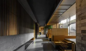 Modern restaurant interior with metallic walls and concrete flooring.