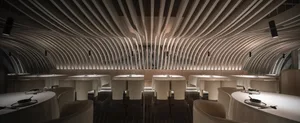 Minimalist restaurant interior featuring wood panels and geometric lighting.