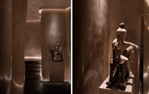 A bronze statue displayed in a modern interior setting.