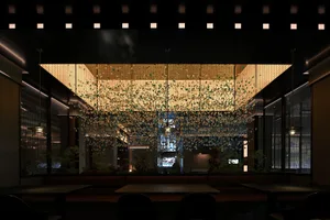 A modern restaurant interior featuring metallic hanging art suspended from the ceiling.
