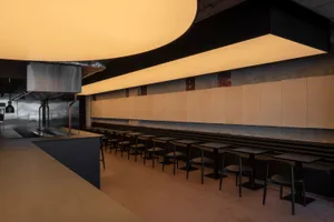 Industrial-style restaurant interior with metal counters and seating.