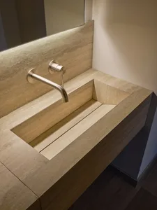 Modern bathroom featuring a stone sink, faucet, and backsplash