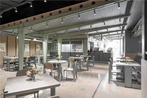 A modern cafe interior with metallic accents, wood furniture, and glass displays.