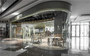 A well-lit modern coffee shop with glass walls reflecting surroundings