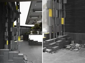 Modern interior space with concrete walls and floors, featuring a central structure made of stacked concrete blocks.