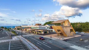 Modern public building with a sloped wooden facade and a view of the ocean.
