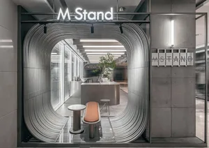 Industrial-themed cafe interior with a metal counter and seating.