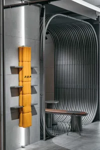 Industrial-themed interior design featuring metal and concrete materials, with a yellow regularization element and a curved m