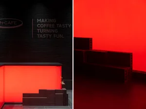 Modern coffee shop interior featuring black materials and red lighting.