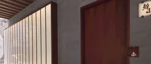 Modern restaurant entrance featuring wooden gates and a concrete wall.