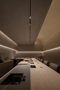 現代餐廳室內，配有木質餐桌、混凝土牆面，以及簡約設計。