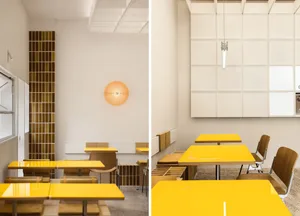 Minimalist design restaurant interior with bright yellow tables and chairs, white walls, and industrial lighting fixtures.
