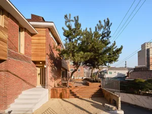 A modern residential home featuring brick, wood, and concrete materials.