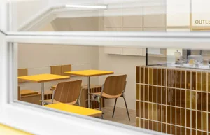 Modern cafe interior with yellow tables and chairs