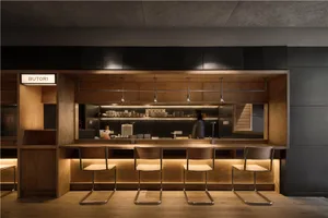 現代工業風餐廳吧台，搭配木質座椅與不鏽鋼細節。