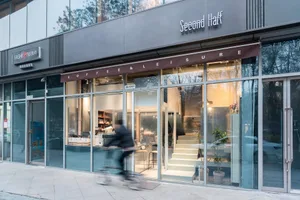 A modern coffee shop exterior with glass facade and a sign reading 'Second Half'.