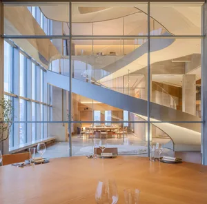 A modern restaurant interior featuring a glass window with a view of the cityscape.