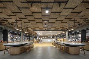 A cozy coffee shop features a unique bamboo ceiling design, providing a comfortable atmosphere for visitors.