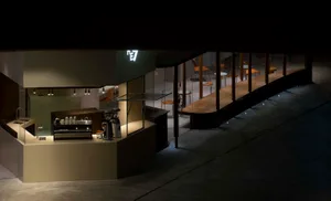 A minimalist coffee shop with a glass counter and modern design elements.