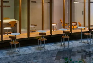 A modern café patio featuring metal and wooden furniture.